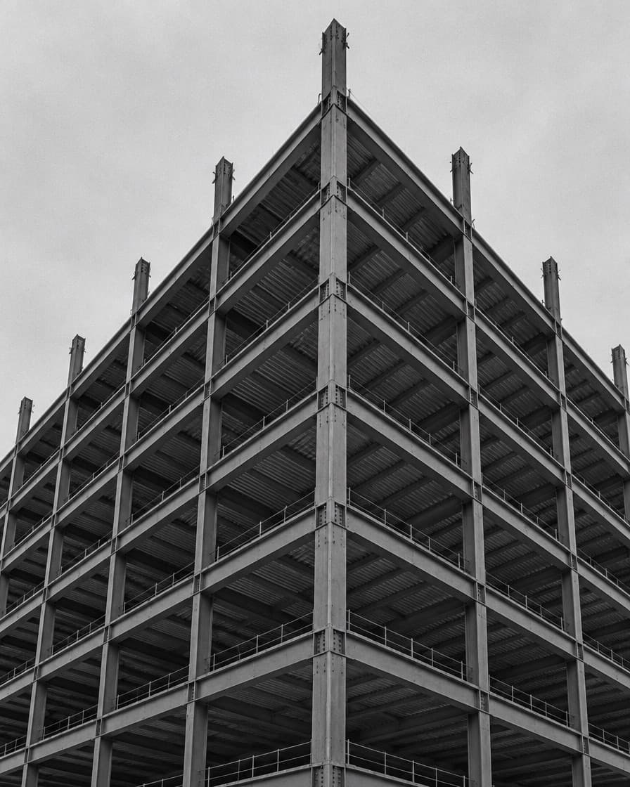 Exposed steel frame of a high-rise under construction against the sky